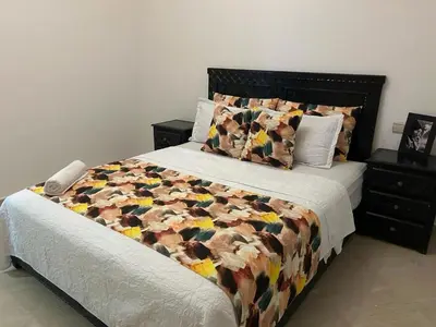 a bedroom with a bed with a comforter and pillows at Appartement au cœur de centre ville in Marrakech