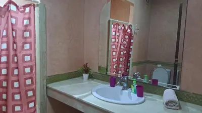 a bathroom with a sink and a large mirror at Appartement au cœur de centre ville in Marrakech