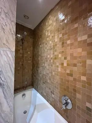 a bathroom with a tub and a shower with a sink at Appartement au palmeraie Marrakech in Marrakech