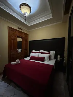 a bedroom with a large bed with a red blanket at Appartement au palmeraie Marrakech in Marrakech