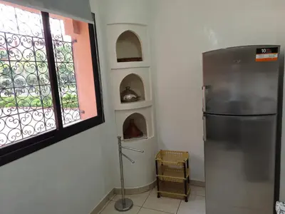 a kitchen with a refrigerator and a window at Appartement élégant près du stade in Marrakech