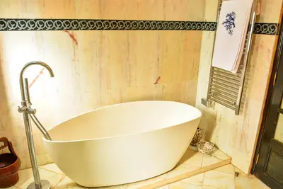 a white bath tub sitting in a bathroom at The Riad Palace - Gym - Spa - Tennis Court in Marrakech