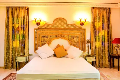 a bedroom with a large bed with a gold frame at The Riad Palace - Gym - Spa - Tennis Court in Marrakech