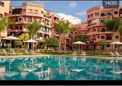 a large swimming pool in front of a large building at Séjour Étoilé in Marrakech