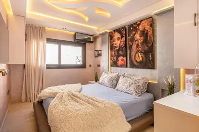 a bedroom with a bed with a large painting on the wall at Modern New Appartement Fully Equiped In Center of guéliz in Marrakech