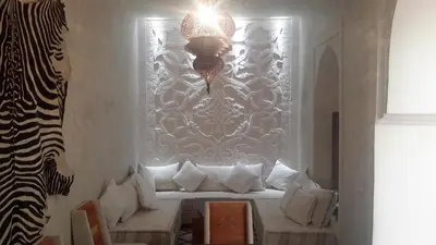 a room with a window with white pillows and a chandelier at Riad Maialou & SPA in Marrakech