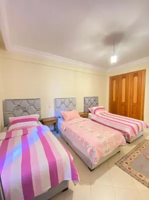 three beds in a room with pink and purple at Superbe Appartement avec Véranda et Terrasse in Marrakech