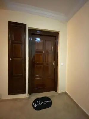 an empty room with two doors and a rug at Superbe Appartement avec Véranda et Terrasse in Marrakech