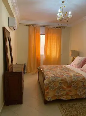 a bedroom with a bed and a dresser and a window at Superbe Appartement avec Véranda et Terrasse in Marrakech