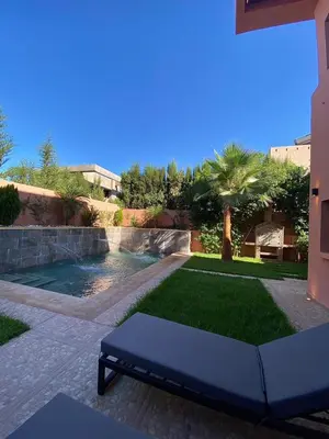 a garden with a pool and a couch in a yard at villa de luxe avec piscine privée in Marrakech