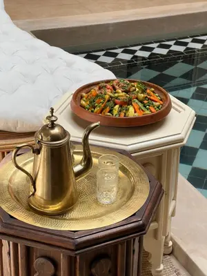 a tea kettle on a table next to a pizza at Riad Excellence in Marrakech