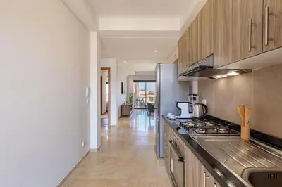 a kitchen with stainless steel appliances and a long hallway at New! Appt Charme, Elégance à NORIA GOLF in Marrakech