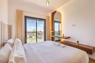 a bedroom with a large white bed with a large window at New! Appt Charme, Elégance à NORIA GOLF in Marrakech