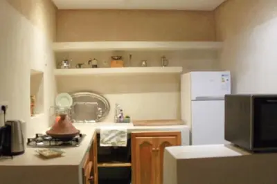 a kitchen with a stove and a white refrigerator at Maison traditionnelle au cœur de la Médina in Marrakech