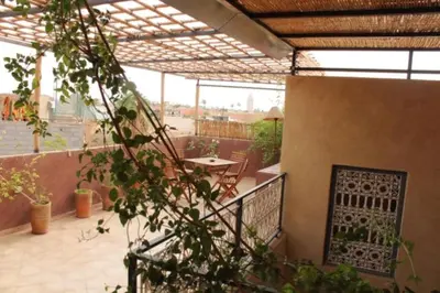 an outdoor patio with a table and a fence at Maison traditionnelle au cœur de la Médina in Marrakech