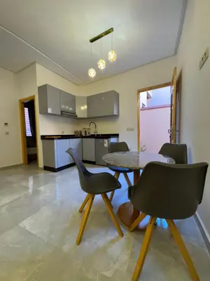a kitchen and dining room with a table and chairs at Square Appart in Marrakech