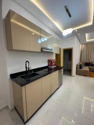 a kitchen with a sink and a living room at Square Appart in Marrakech