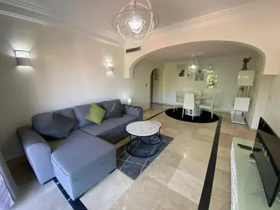 a living room with a blue couch and a table at Appartement cosy à deux pas du Jardin Majorelle in Marrakech