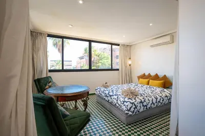 a hotel room with a bed and a table at Élégant appartement avec terrasse au cœur Guéliz in Marrakech