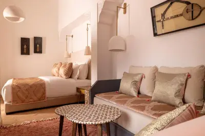 a bedroom with a bed and a couch and a table at Riad Laz Mouassine & Wellness in Marrakech