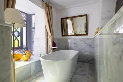 a bathroom with a white tub and a mirror at Riad Laz Mouassine & Wellness in Marrakech