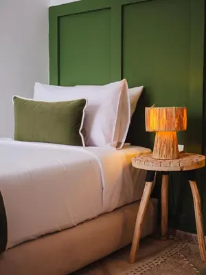 a bed with a night stand next to a side table at Riad Abati Piscine Privee avec Petit dejeuner et Terrasse in Marrakech