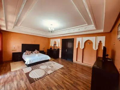 a large room with a bed and a ceiling at Naoura House in Marrakech