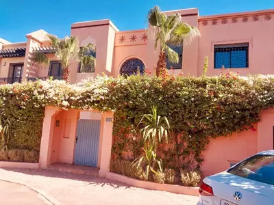 a pink house with flowers on the side of it at Naoura House in Marrakech