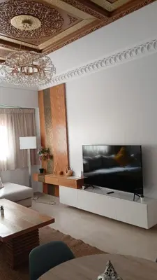 a living room with a large flat screen tv at Bel Appartement meublé avec Piscine, l'hivernage à Marrakech in Marrakech