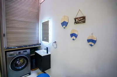 a laundry room with a washing machine and umbrellas on the wall at Appartement cosy au cœur de Semlalia in Marrakech
