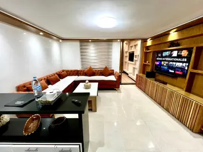 a living room with a couch and a television at Appartement cosy au cœur de Semlalia in Marrakech