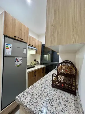 a kitchen with a refrigerator and a counter top at Appartement a Gueliz in Marrakech