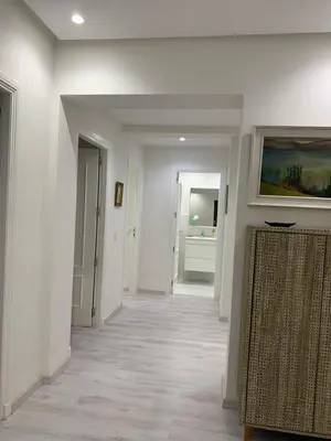 a hallway with white walls and a television on a wall at Luxury Apartment in City Center of Marrakech in Marrakech
