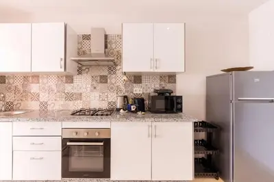 a kitchen with white cabinets and a stainless steel refrigerator at Luxury and Healthy designed Apartment with pool in Marrakech