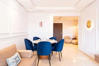 a dining room with a table and blue chairs at Luxury and Healthy designed Apartment with pool in Marrakech