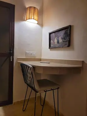 a desk with a chair and a light on a wall at Dar Amazigh mit 3 Schlafzimmern in Marrakech