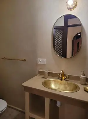 a bathroom sink with a mirror and a toilet at Dar Amazigh mit 3 Schlafzimmern in Marrakech