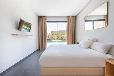 a bedroom with a large white bed and a window at Villa Relax in Marrakech