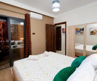 a bedroom with a large bed and a mirror at Appartement Piscine & Parking in Marrakech