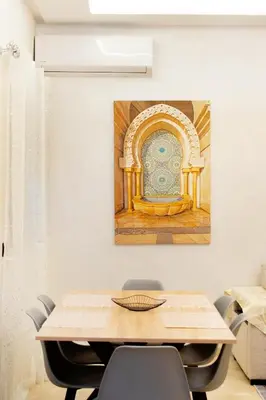 a dining room with a table and a painting on the wall at Appartement Piscine & Parking in Marrakech