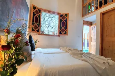 a bedroom with a bed and a stained glass window at Riad LakLak Nouvelle 400m2 mit Pool in der Medina in Marrakech