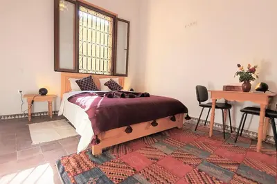 a bedroom with a bed and a table and a desk at Riad LakLak Nouvelle 400m2 mit Pool in der Medina in Marrakech