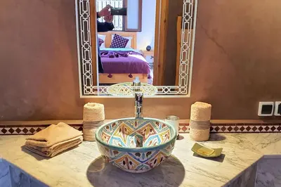 a bathroom with a bowl on a counter with a mirror at Riad LakLak Nouvelle 400m2 mit Pool in der Medina in Marrakech