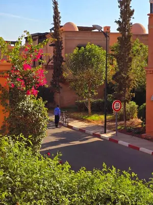 a man walking a bike down a street at Dar Ou Bahssou in Marrakech