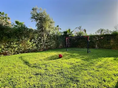 a soccer ball sitting on the grass in a yard at Villa Léna détente en famille ! in Marrakech