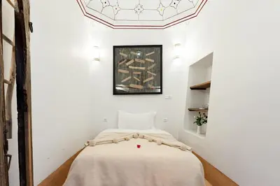 a bedroom with a bed in a white room at Riad Petit Pouce 40m2 in der Medina mit Terrasse in Marrakech