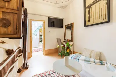 a room with a bed and a table with a vase of flowers at Riad Petit Pouce 40m2 in der Medina mit Terrasse in Marrakech
