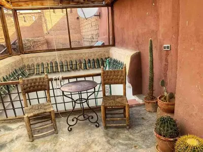 a patio with chairs and a table and a window at Riad Petit Pouce 40m2 in der Medina mit Terrasse in Marrakech