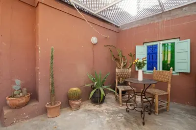 a patio with a table and chairs and plants at Riad Petit Pouce 40m2 in der Medina mit Terrasse in Marrakech