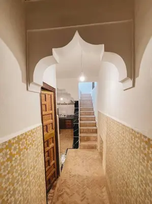 a hallway with stairs and a room with an archway at Riad Dar Habiba 120m2 in der Medina mit Terrasse in Marrakech